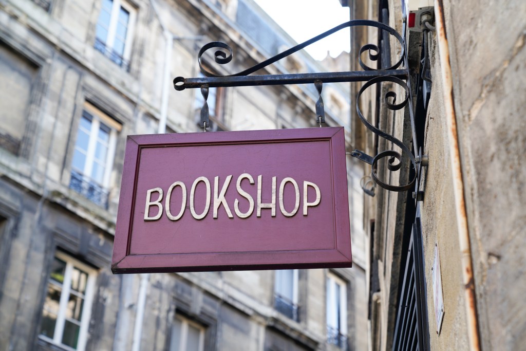 a vintage bookshop wooden sign over an old city street